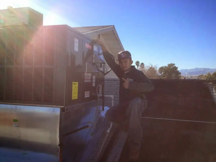 HVAC technician performing Heat Pump Repair on a rooftop unit in Air Force Academy